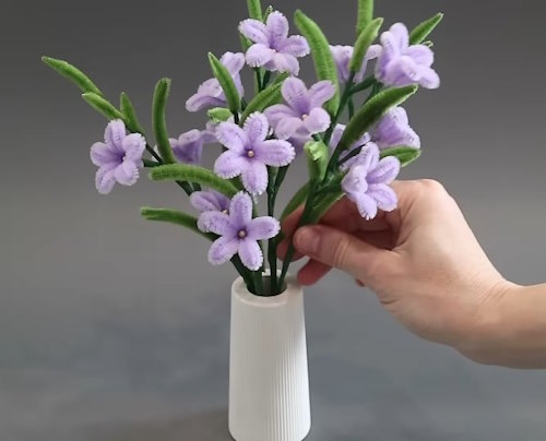 Placing DIY Pipe Cleaner Starflowers into a small vase by hand