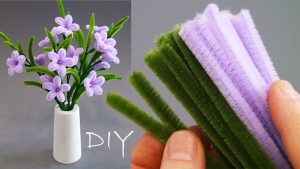 DIY Pipe Cleaner Starflowers displayed in a mini vase with crafting materials