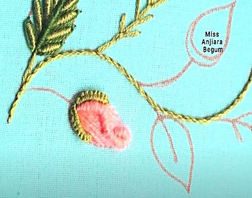 Pink flower embroidery in progress using layered satin stitches